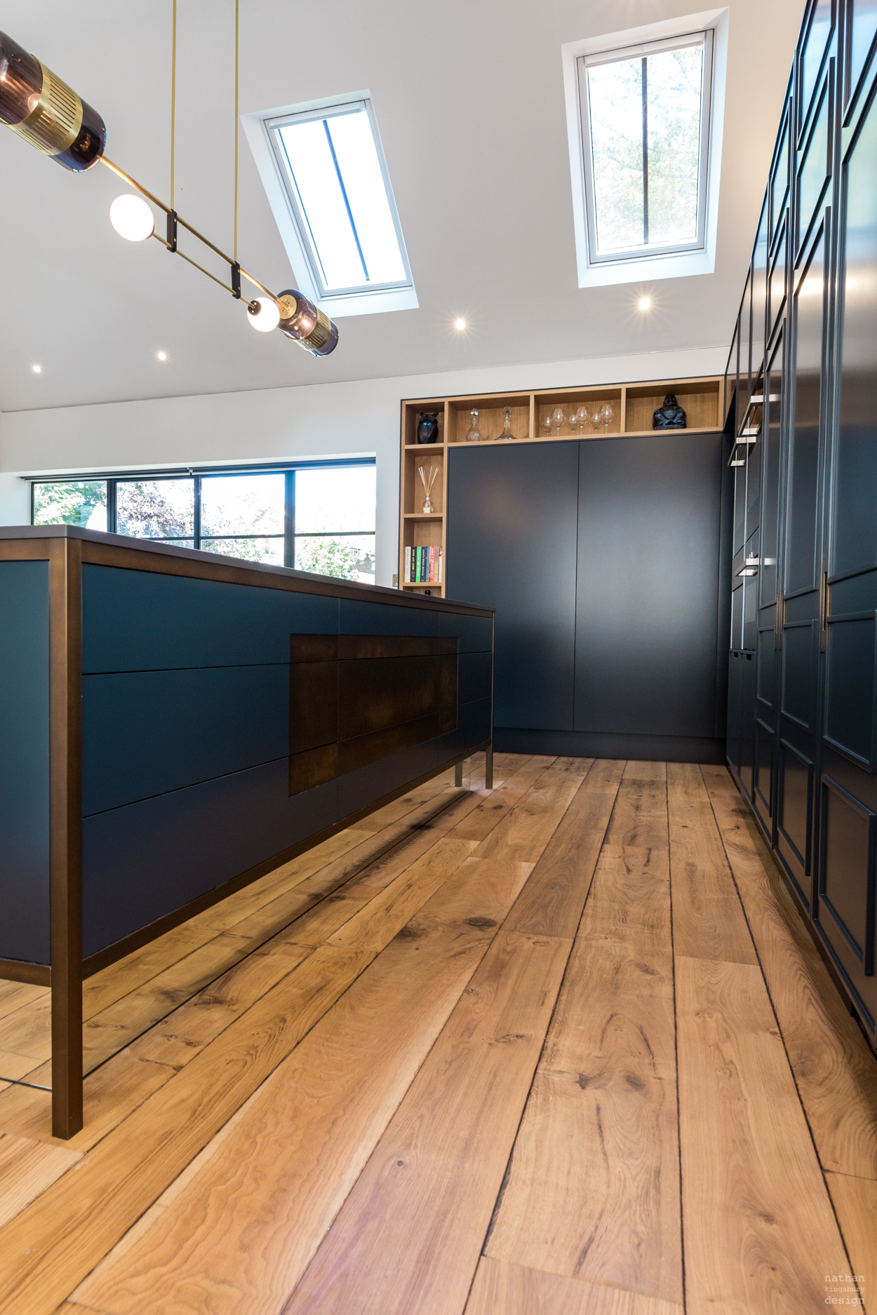 dark bespoke kitchen island with brass details and mirrored plinth reigate surrey